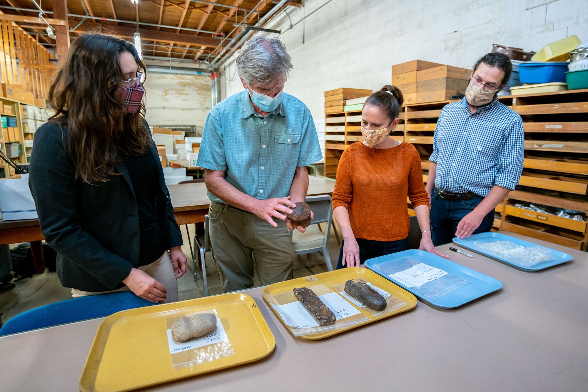 (From left) Postdoctoral scholar Katharine Napora, Webb Museum Director George Crothers, Museum Curator Lisa Guerre and graduate student Alex Metz discuss the grooved maul Crothers is holding. Photo courtesy: UK Research.