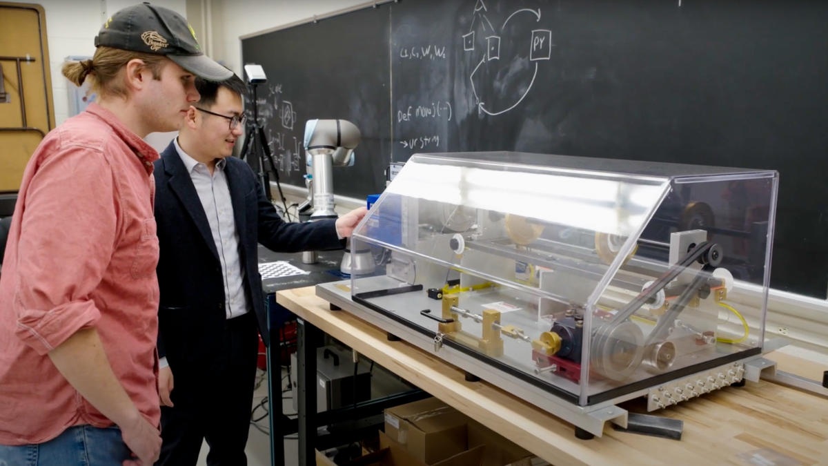 Peng “Edward” Wang and research student looking at innovative machinery.